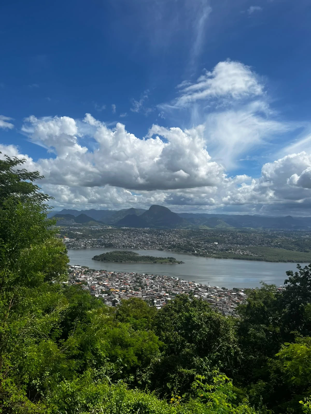 Vista panorâmica da Grande Vitória, com montanhas, água e vegetação